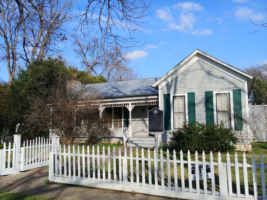 Historic home with white picket fence and Texas historical marker in Georgetown