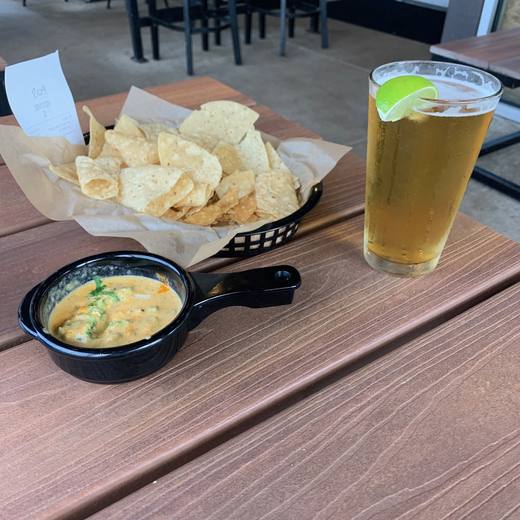 Queso, chips and a beer on the patio at Torchy’s Tacos